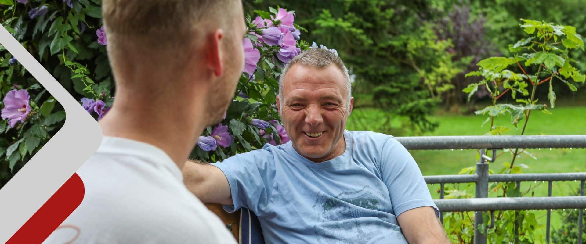 Betreuungskraft im Gespräch mit einem Bewohner im Außenbereich