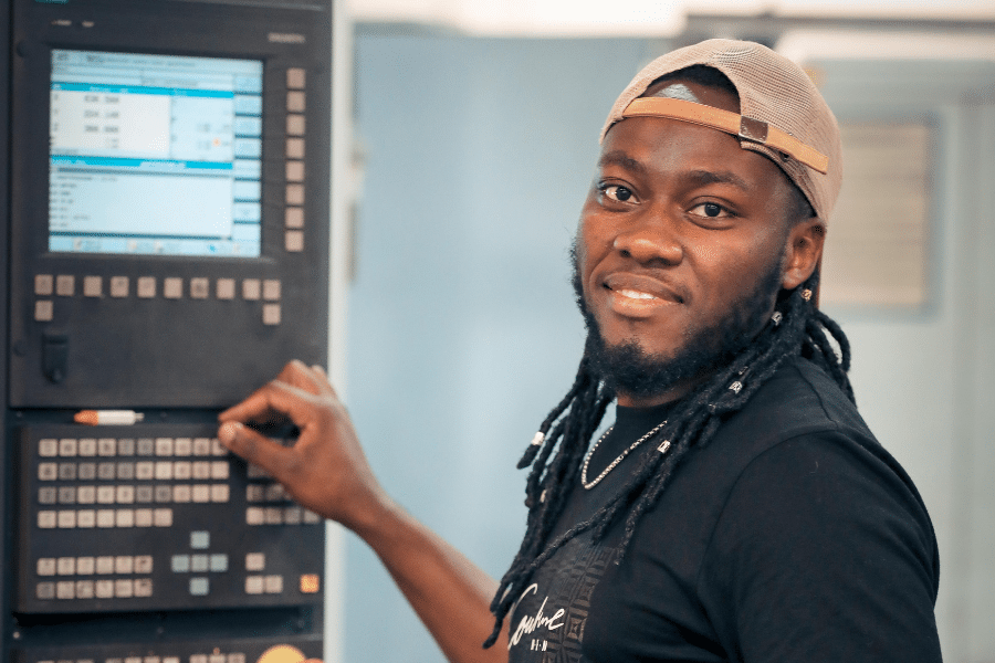 junger Mann arbeitet an einer CNC-Maschine
