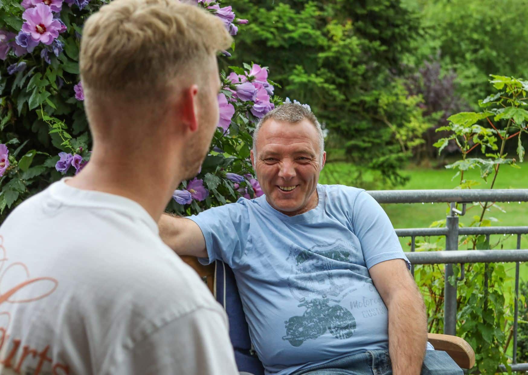 Betreuungskraft im Gespräch mit einem Bewohner im Außenbereich