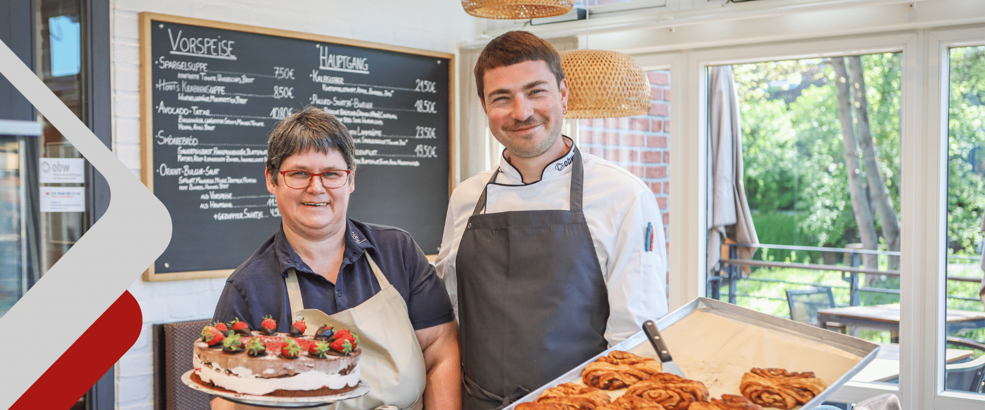 Zwei Mitarbeiter präsentieren Kuchen im Henri's