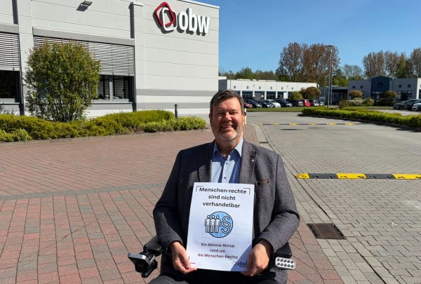 Geschäftsführer Jörn Malanowski hält ein Plakat hoch