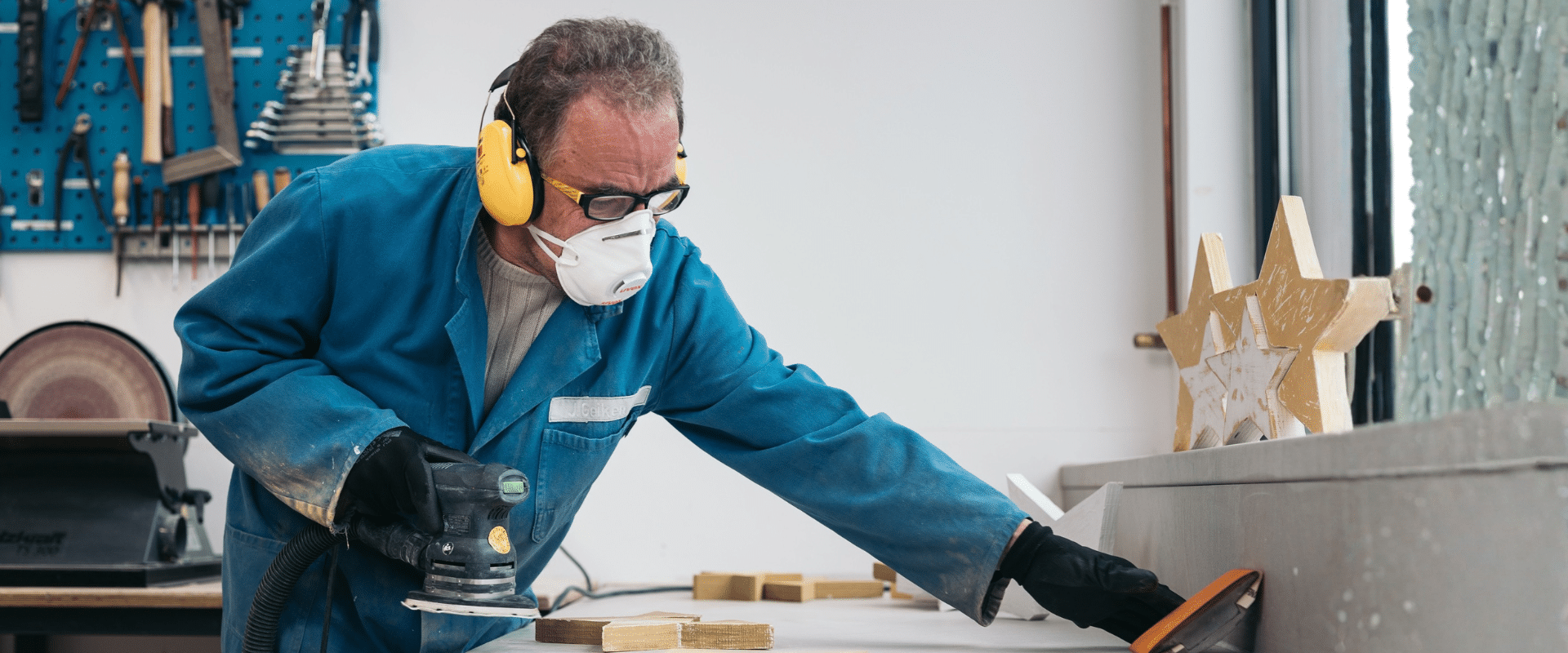 Mann schleift in Werkstatt Holzsterne