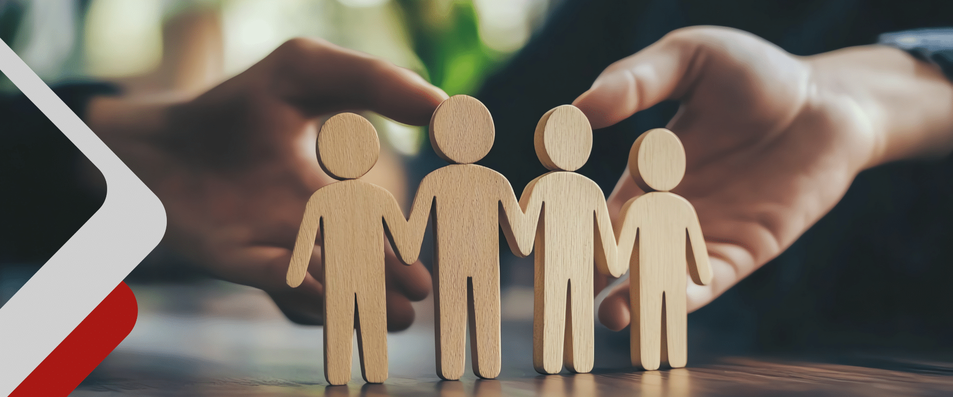 Figurensymbole aus Holz vor zwei haltenden Händen