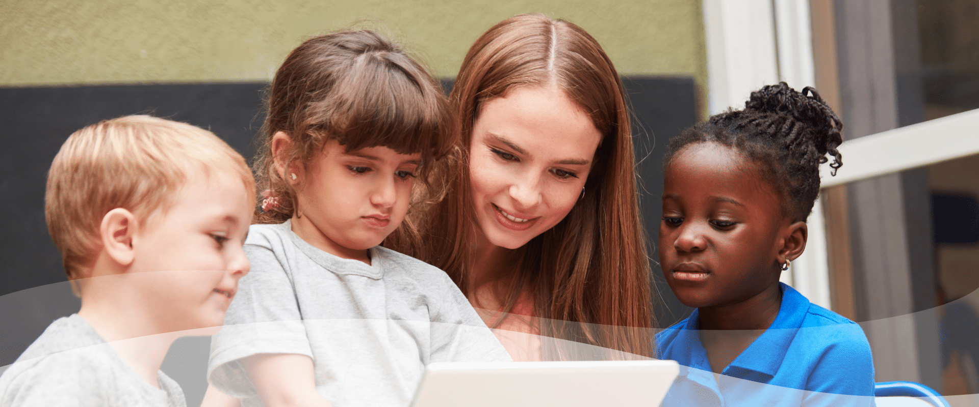 Junge Frau zeigt Kindern etwas auf dem Tablet