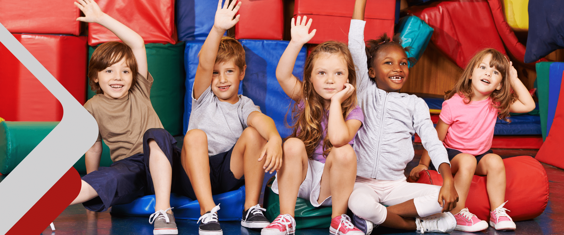 Grundschulkinder sitzen in der Turnhalle
